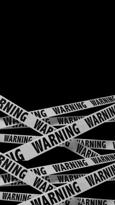 black and white photo of warning tape with the word warning on it in multiple languages