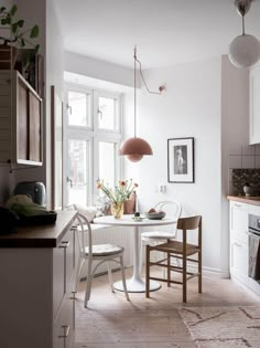 a white table and chairs in a small room