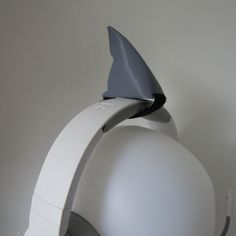 a white object with a shark fin sticking out of it's back end on the wall