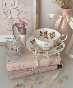 a table topped with books and jewelry next to a vase