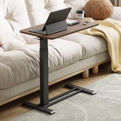 a laptop computer sitting on top of a wooden table next to a white futon