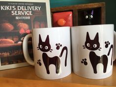 two coffee mugs with black cats on them