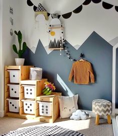 a child's room with mountains painted on the wall and toy storage bins