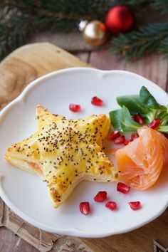 a white plate topped with star shaped food next to a green leafy plant on top of a wooden table