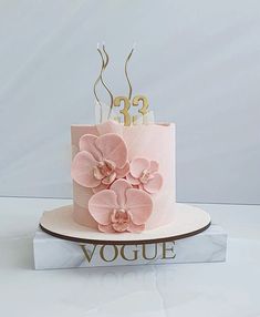 there is a pink cake with flowers on it and the number twenty three in gold