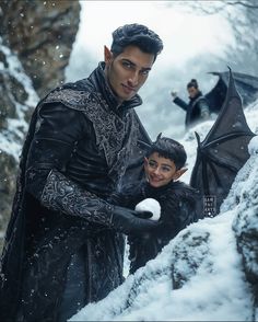 a man and boy standing in the snow next to each other, one holding an umbrella