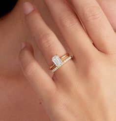 a woman's hand with a diamond ring on it