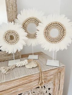 two white flowers are placed next to each other on a table with an ornate mirror