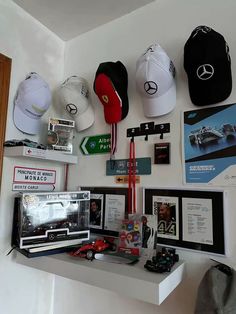 several hats are hanging on the wall above a table with other items and memorabilia around it