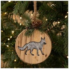 a wooden ornament with a wolf on it hanging from a christmas tree branch