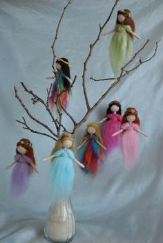 five dolls are sitting on branches in front of a white background