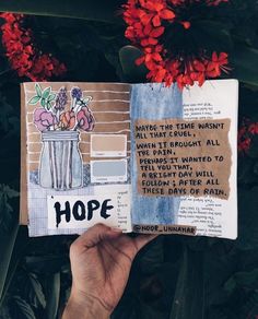 someone is holding up an open book with flowers in it and the words hope written on it