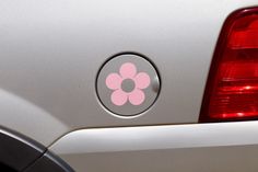 a pink flower sticker is on the back of a car's tail light