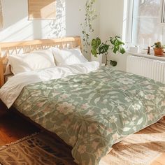 a bed sitting in a bedroom next to a window with potted plants on it