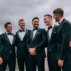 a group of men in tuxedos standing next to each other