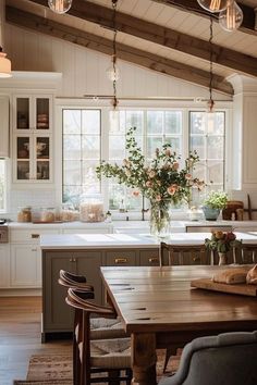 a kitchen with an island, table and chairs next to the window in front of it