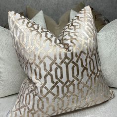 two decorative pillows sitting on top of a bed