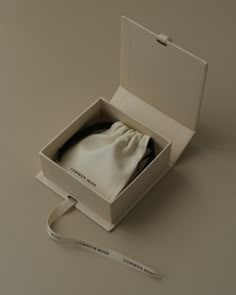 an open white box with a tie in it and a pair of scissors next to it