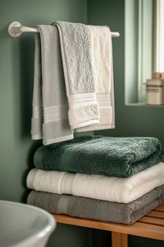 Light sage green bathroom with sage green bathroom cabinets and coordinating towels natural light streaming