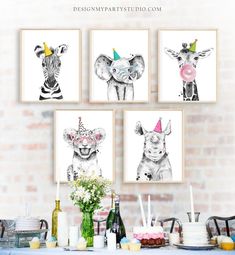 three giraffes and two zebras wearing party hats are hanging on the wall