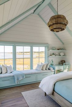 a bedroom with two windows and a bed in the corner, along with a rug on the floor