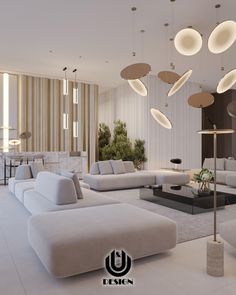 a living room with white couches and lights hanging from the ceiling above them,