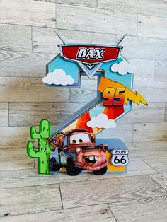 the letter k is made out of cardboard and has cars on it, including a cactus