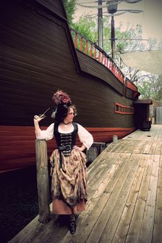 a woman in a pirate costume standing on a dock