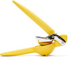 a pair of yellow scissors are open on a white background with clippings in it