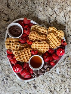 waffles and strawberries on a heart shaped plate with chocolate sauce in the middle