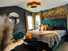 a bedroom with green velvet headboard and gold accents on the walls, along with black furniture