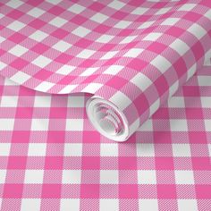 a pink and white checkered tablecloth with a roll of paper on top of it