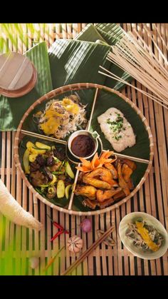 an assortment of food on a plate with chopsticks, rice and other items