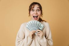 a woman holding money in front of her face and making a funny face with it's mouth