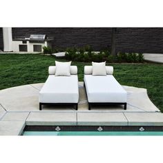 two white couches sitting next to a swimming pool