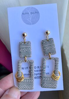 a pair of earrings is shown in front of a card