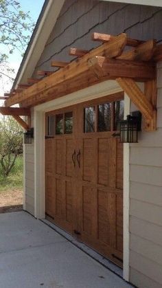 a garage with two wooden doors and a pergolated roof on the side of it