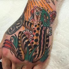 a person's hand with a tiger and flowers tattoo on the left side of their arm