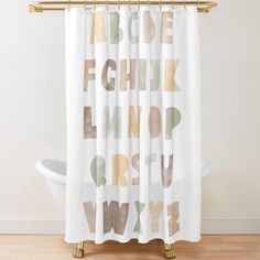 a shower curtain with the words abc and w in different colors on it, sitting next to a bathtub