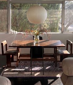 a dining room table and chairs in front of a large window