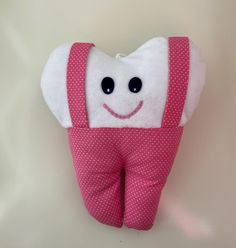 a toothbrush holder with pink and white polka dots on it, holding a smiling tooth