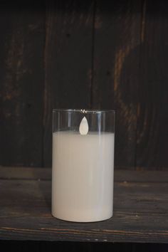 a white candle with a small tear on it