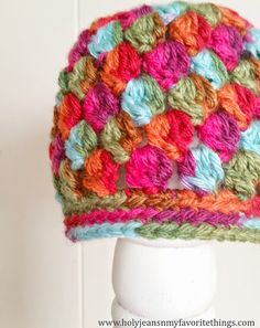 a multicolored crocheted hat on a white mannequin head