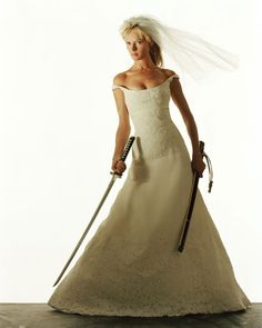 a woman in a wedding dress holding two swords