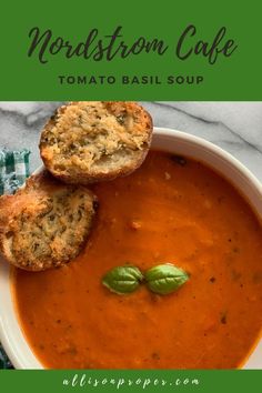 a bowl filled with tomato soup and two pieces of bread