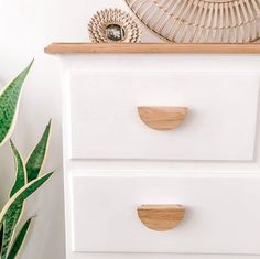 a white dresser with two drawers and a fan on top