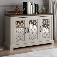 a white cabinet with mirrored doors and books on top