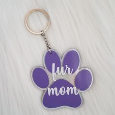 a purple keychain that says fur mom with a paw print on the front