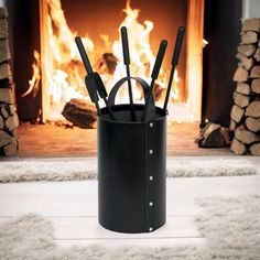 there is a black container with utensils in front of a fire place on the floor