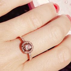 a close up of a person's hand with a diamond ring on their finger